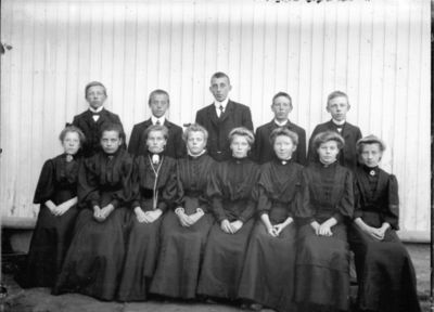 Gruppebilde 1900 - 05  Ytre Enebakk
Konfirmasjonsbilde 8 jenter, 5 gutter.
Bak fra venstre ser vi Ottar Lorentsen f.1893 
Nøkkelord: gruppebilde;konfirmasjon;ytre;gutter;jenter;1883;ottar;lorentsen;pyntet;kjole;dress;smykker