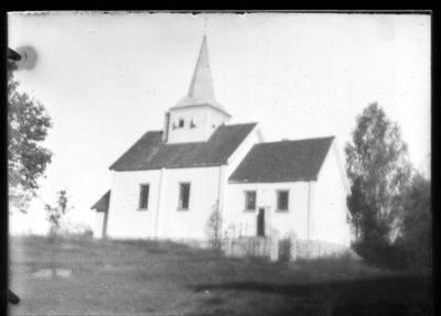 Bygning 1900 - 10  Ytre Enebakk 
Mari kirke sett fra langsiden. Bildet uskarpt.
Nøkkelord: bygning;kirke;mari;kirketårn;trær;tre;trapp;gjerde;gravplass;port