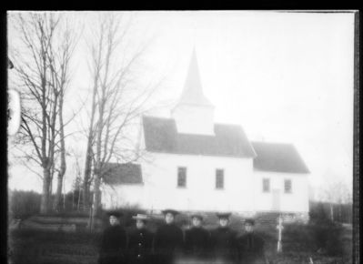 Bygning 1900 - 10  Ytre Enebakk 
Mari kirke sett fra langsiden. Bildet uskarpt. 6 jenter i forgrunnen.
Nøkkelord: bygning;kirke;mari;jenter;svart;tre;trær;kirketårn;uniform;hatt;damer;gjerde;ytre
