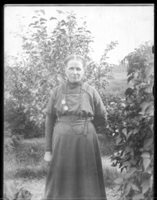 Portrett 1900 - 10
Stående kvinne, utendørs, sommer.
Keywords: portrett;kvinne;pyntet;kjole;smykke;smykker;utendørs;sommer;tre;trær;dame;stående