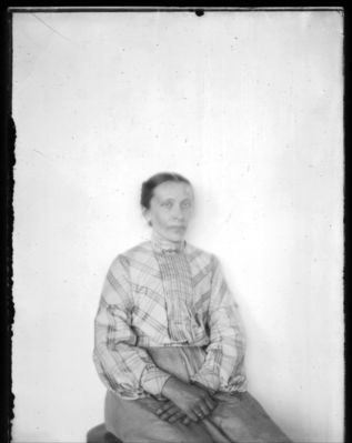 Portrett Kvinne
Portrett av sittende kvinne, ca 40 år. 
Kan det være Anette Hansen ?
Nøkkelord: portrett;kvinne;1900