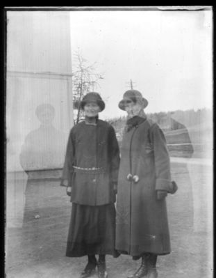 Portrett ca. 1920
To kvinner i yttertøy utendørs. Bildet dobbelteksponert.
Keywords: portrett;kvinner;damer