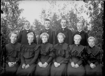 Gruppebilde 1900 - 05  Ytre Enebakk
Konfirmasjonsbilde 6 jenter, 4 gutter. Svarte kjoler.
Nøkkelord: gruppebilde;konfirmasjon;ytre;gutter;jenter;kjoler;smykker;trær