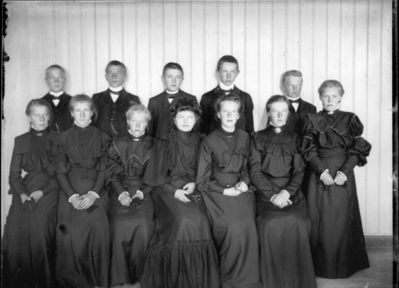 Gruppebilde 1900 - 05  Ytre Enebakk
Konfirmasjonsbilde 7 jenter, 5 gutter. Svarte kjoler. Innendørs.
Keywords: gruppebilde;konfirmasjon;ytre;gutter;jenter;kjoler;dress;pyntet;innendørs;smykker