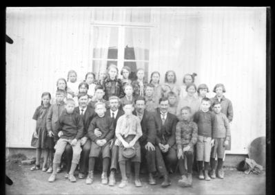 Gruppebilde  1920 - 30
Gruppe barn, fire voksne menn oppstilt utendørs.
Nøkkelord: gruppe;barn;menn